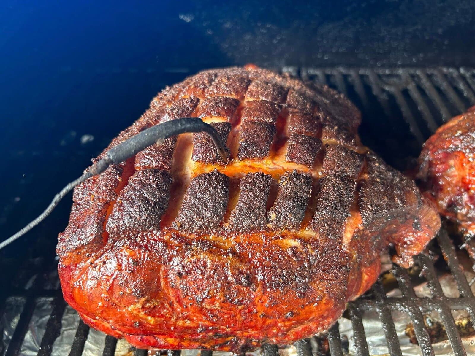 Scored pork shoulder in the smoker